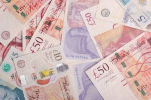 Photo shows bank notes of £5, £20, £10 and £50 scattered among eachother.