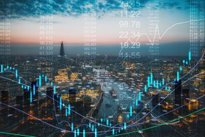 A cityscape of London at dusk with the River Thames and illuminated buildings, overlaid with financial data, stock market charts and candlestick graphs, symbolising global finance and trading activity