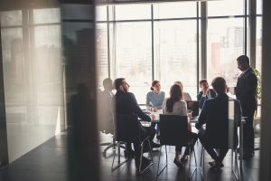 An image showing businesspeople seated around a table at an office meeting.