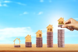 Home sitting on pile of coins