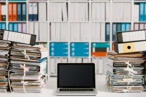 Pile-of-documents-and-laptop-shutterstock_1020181930-Stock-Asso-300x200.webp