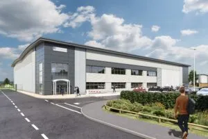 CGI of Hillwood's modern industrial building with the sign "Hillwood" on the front. The building has large glass windows and grey-and-white exterior panels. Several people are walking near the entrance, and cars are parked in the adjacent parking lot. The scene is set under a bright, partly cloudy sky with landscaped greenery along the road in the foreground.