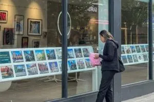 Woman-looking-in-estate-agent-window-shutterstock_2335496855-Brookgardener-scaled-e1761147267715-300x200.webp