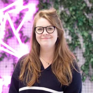 Roseanna Hart is standing in front of a decorative wall
